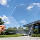 Clear solid polycarbonate roofing sheet held against the sky