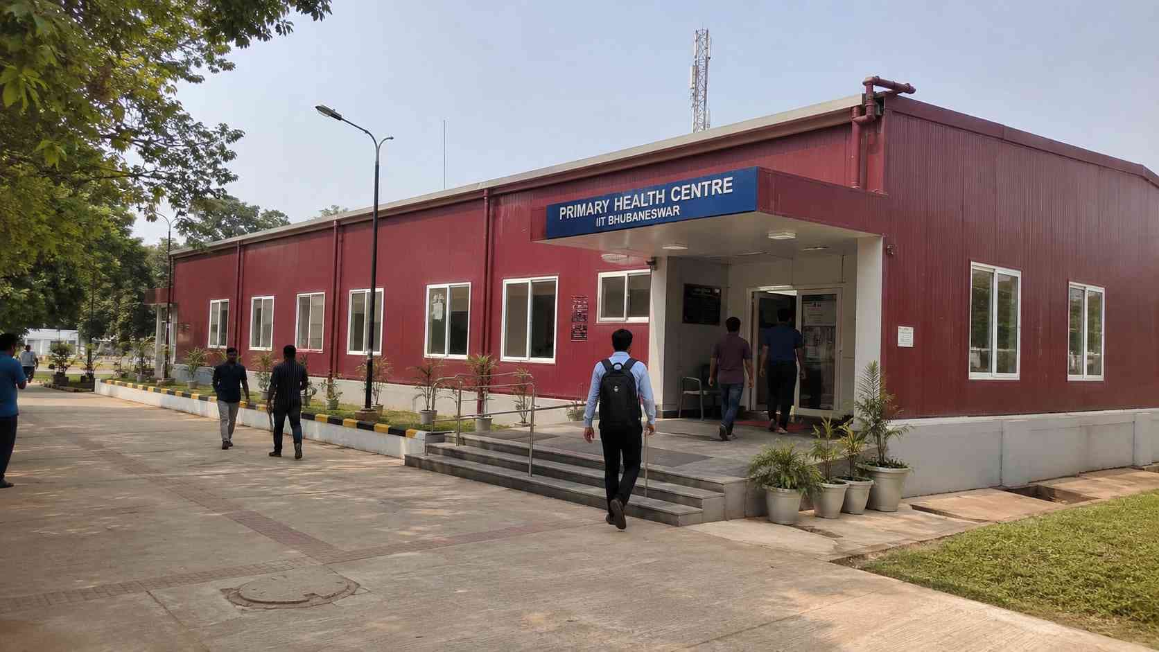 Burgundy-red prefabricated institutional building such as a clinic or school block, in use.