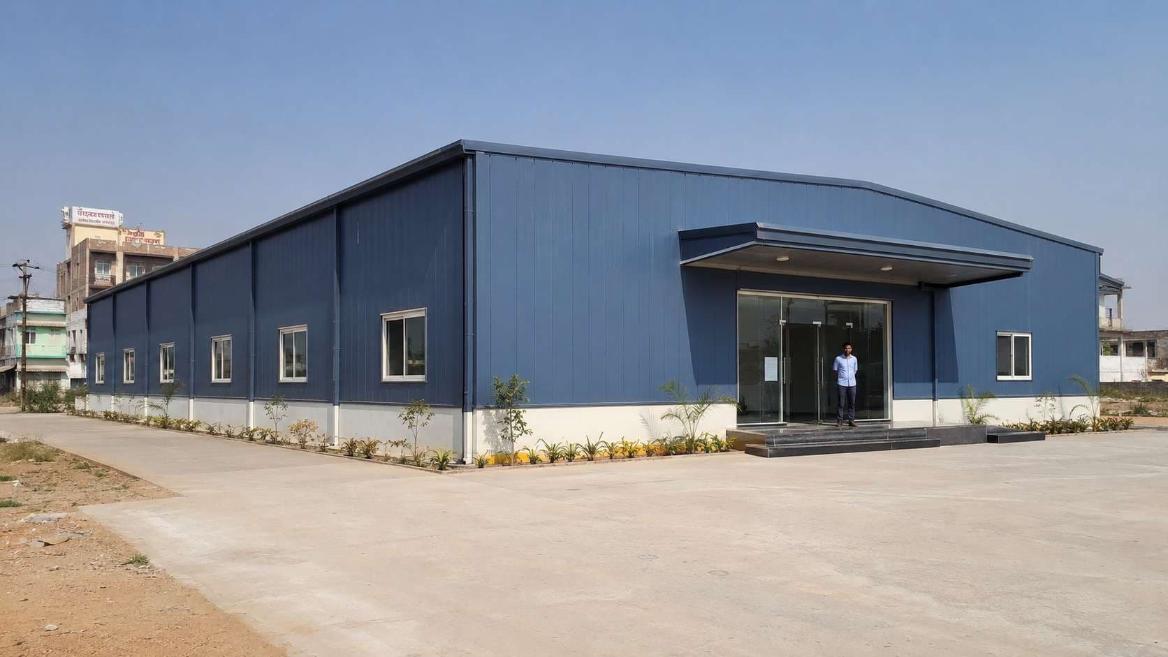 Steel-blue prefabricated commercial building completed on an Indian plot, built by SAMAN.