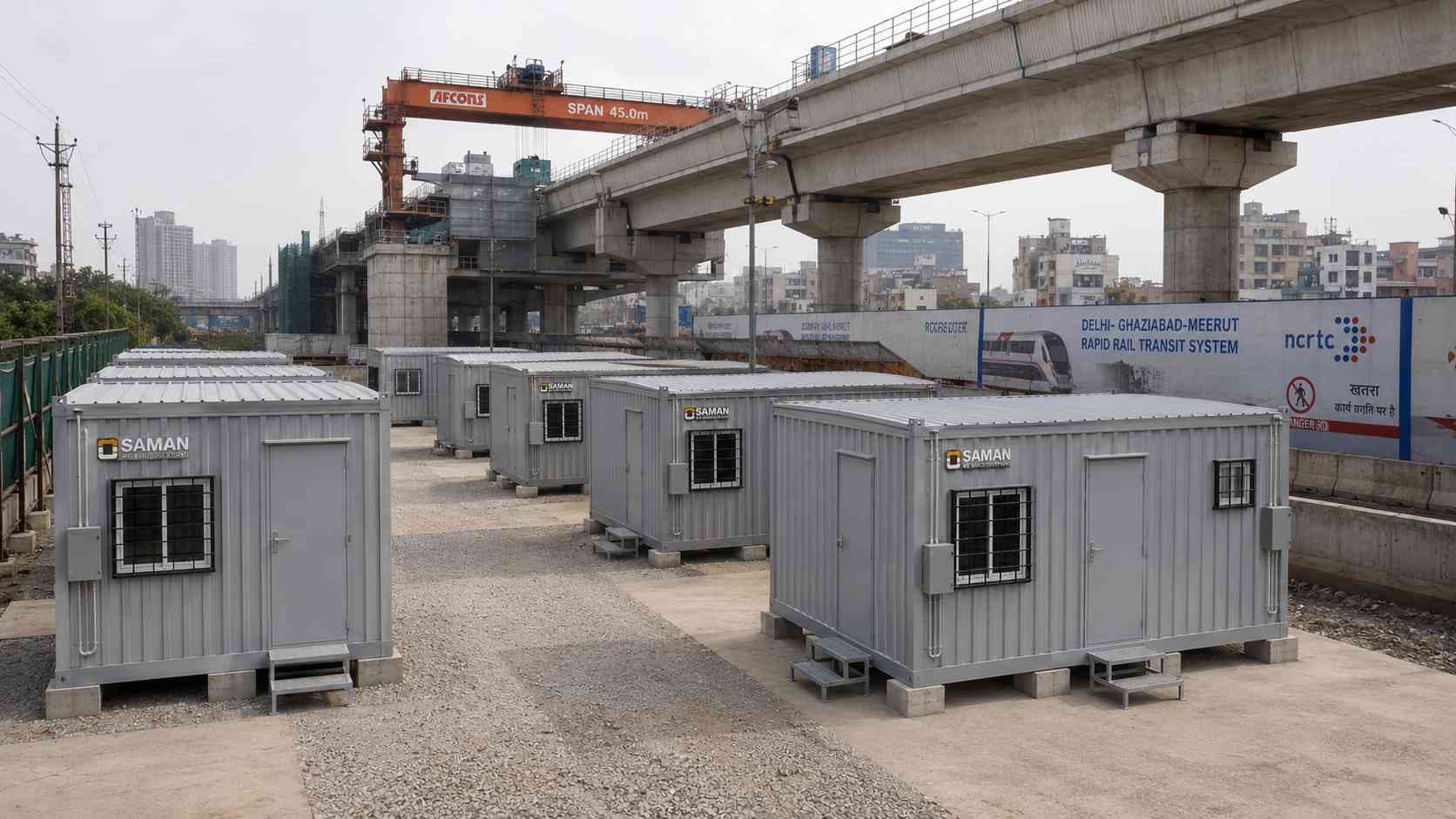Pearl Grey SAMAN prefab labor hutments arranged in a compact camp beside a metro rail construction site.