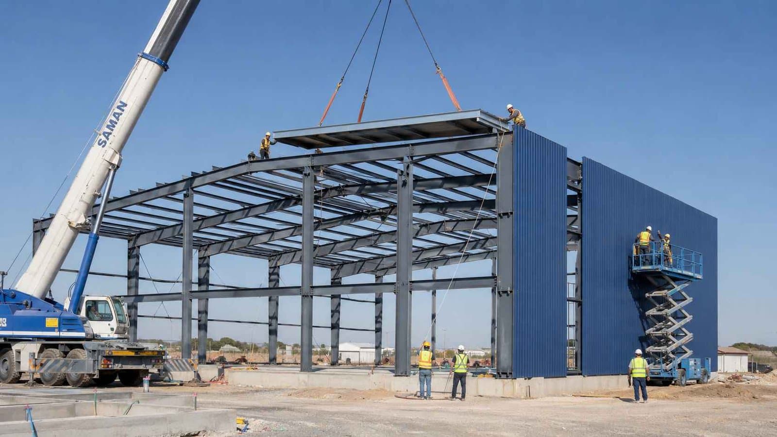 Crew erecting a steel frame and fixing royal-cobalt panels during prefabricated construction.