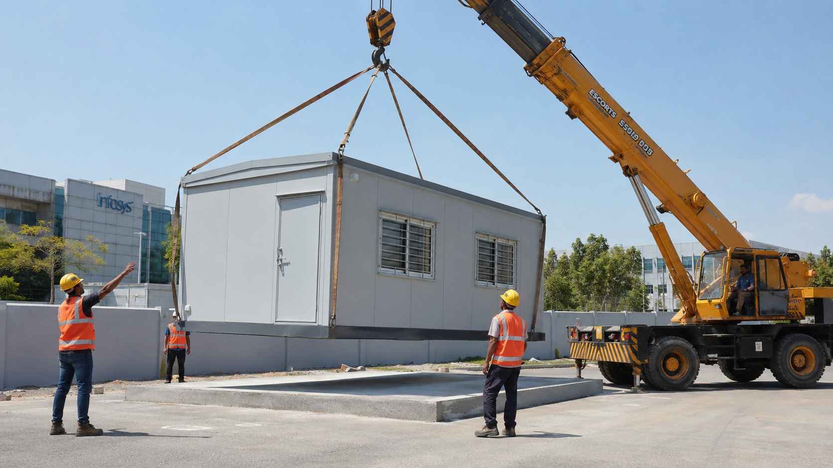 Site placement of a complete fitted prefabricated portable office cabin being lowered by crane onto a prepared concrete base