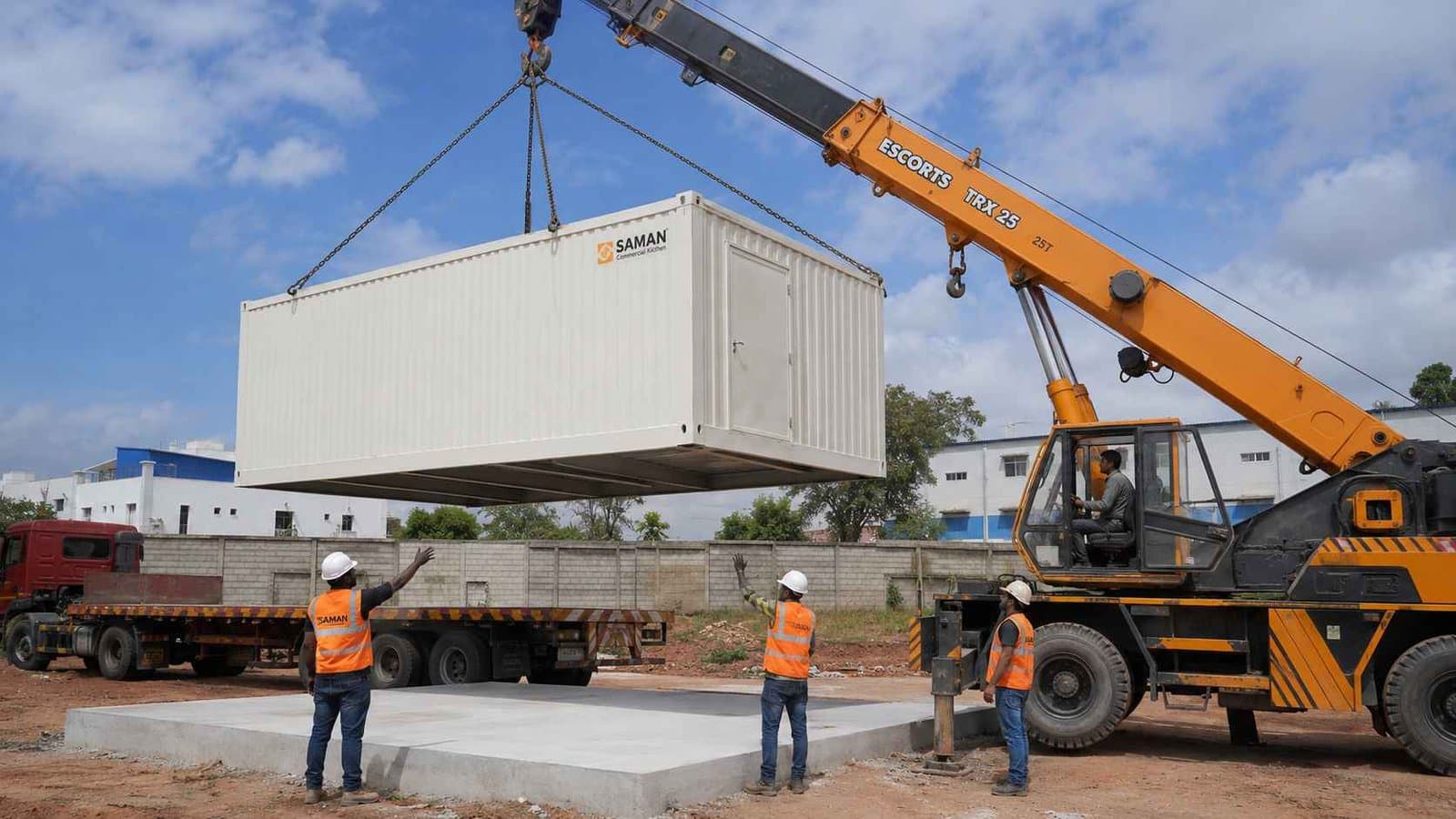 Crane installing a SAMAN restaurant food container onto a prepared concrete pad at a Whitefield Bangalore site