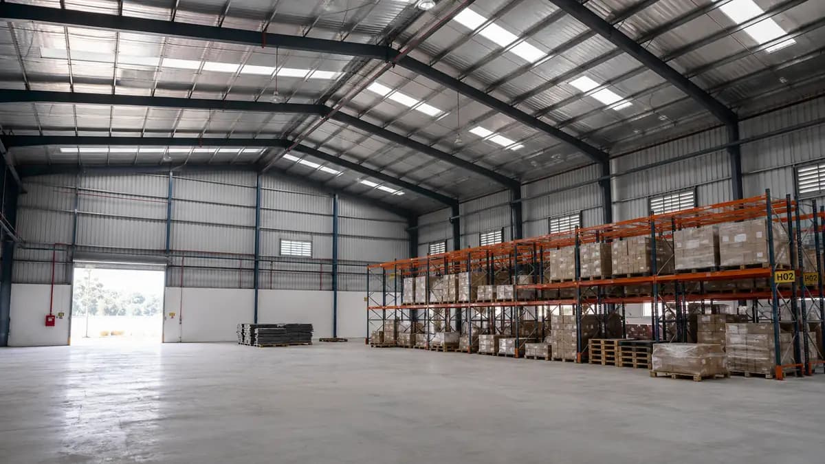 Interior of an industrial shed showing column-free clear span, tall eave height and pallet racking