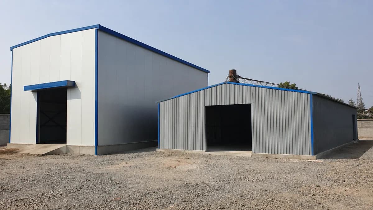 Tall insulated warehouse shed next to a shorter sheet-clad storage shed showing different industrial shed types
