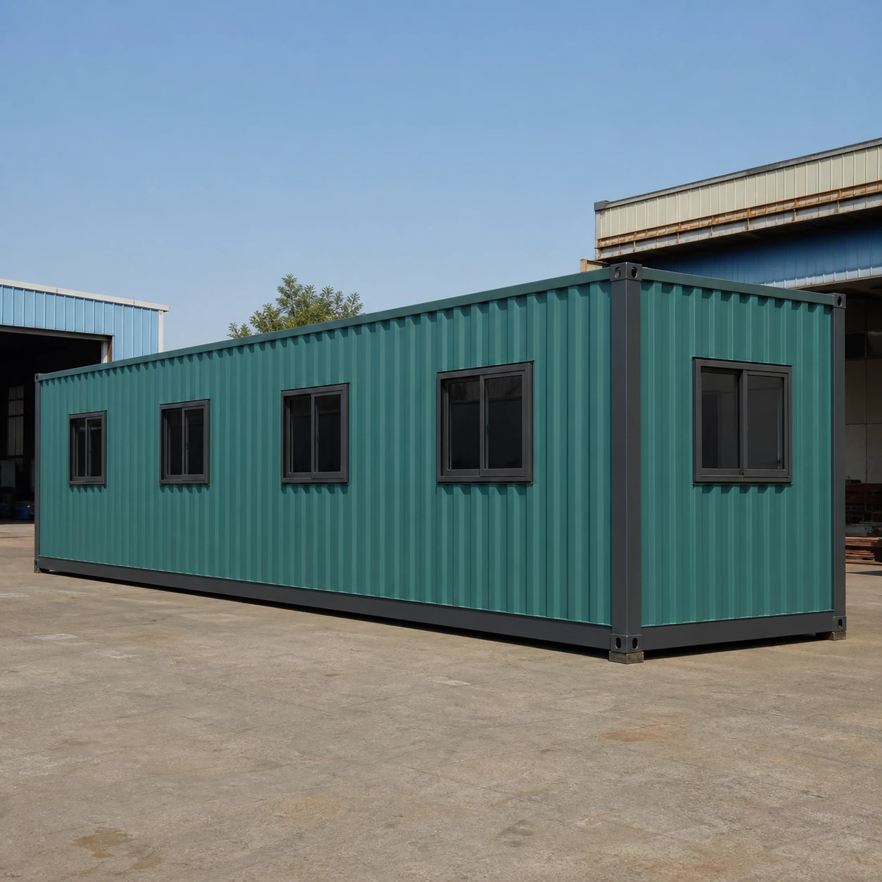 Rear long wall of the muted teal flat-pack office with four evenly spaced sliding windows and no door