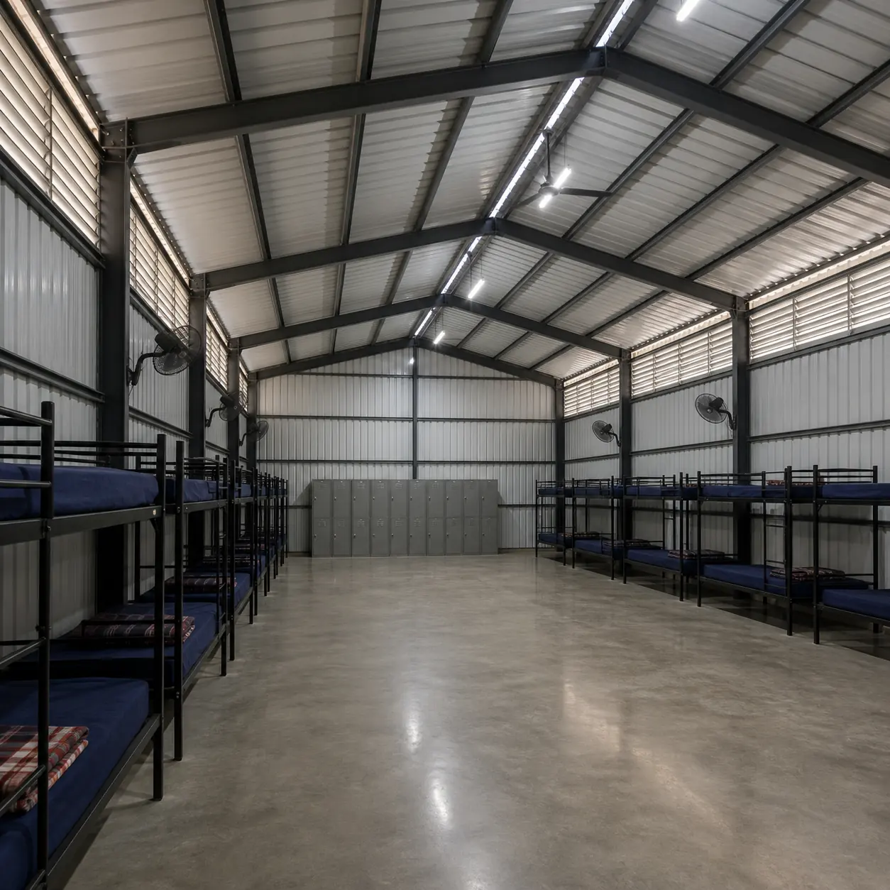 Wall-mounted fans and louvre bands along both walls of the 20x30 ft labour shed hall