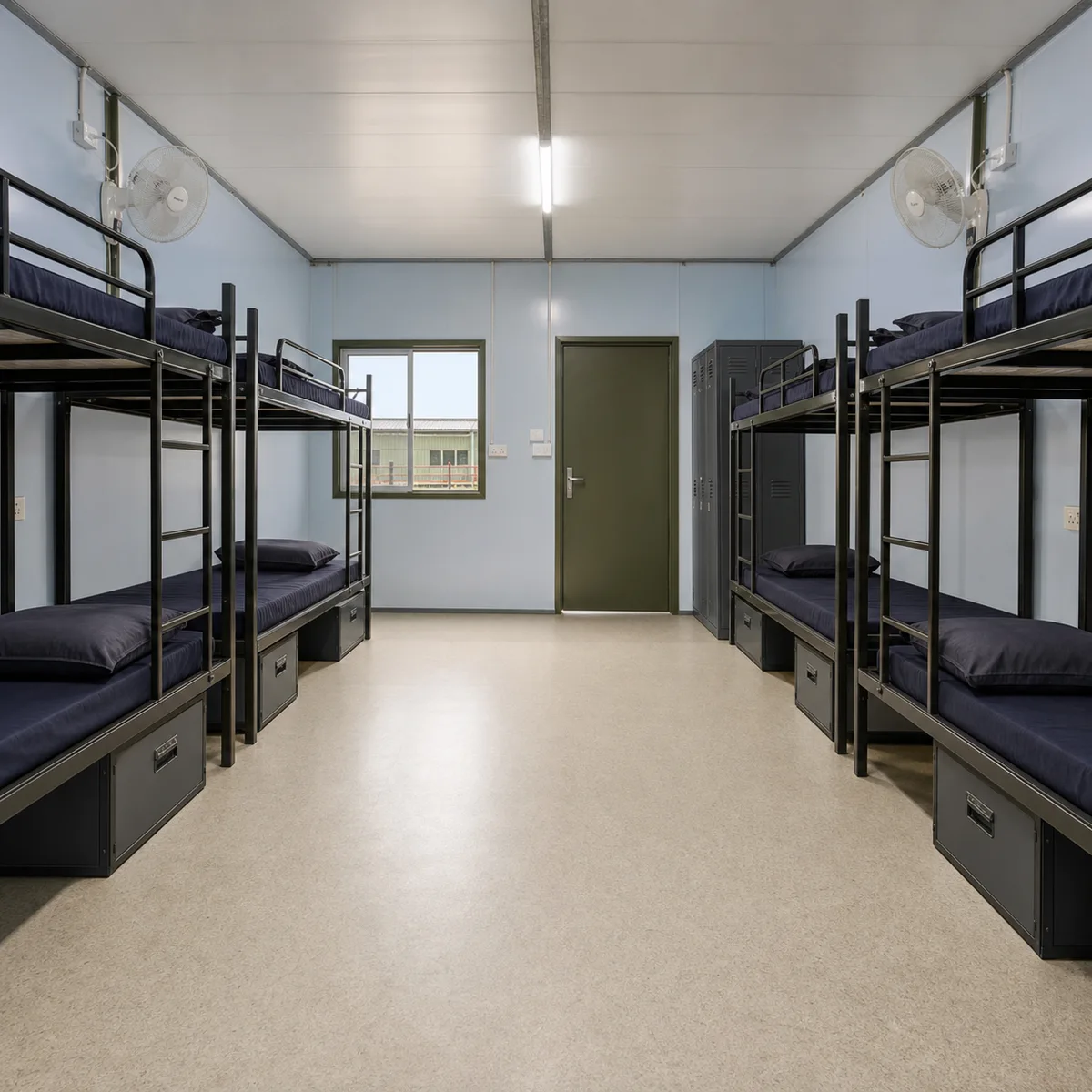 Inside a 120x24 ft G+1 prefab labour camp, the return view toward the door in the bolted panel block, sleeping planned for 115 to 144 workers.