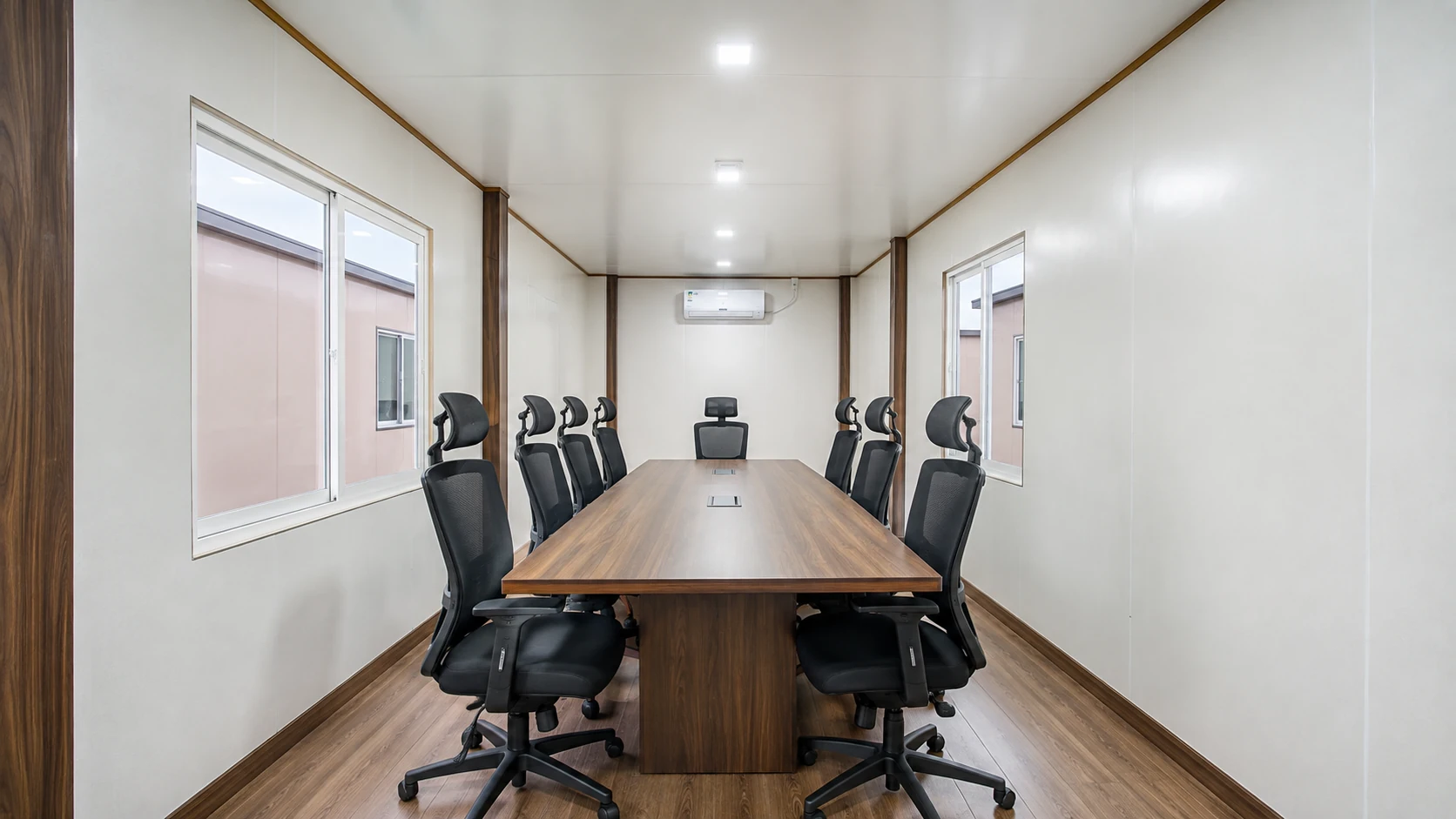 Off-white PUF panel meeting room interior with a boardroom table, chairs, split AC and ceiling LED panels